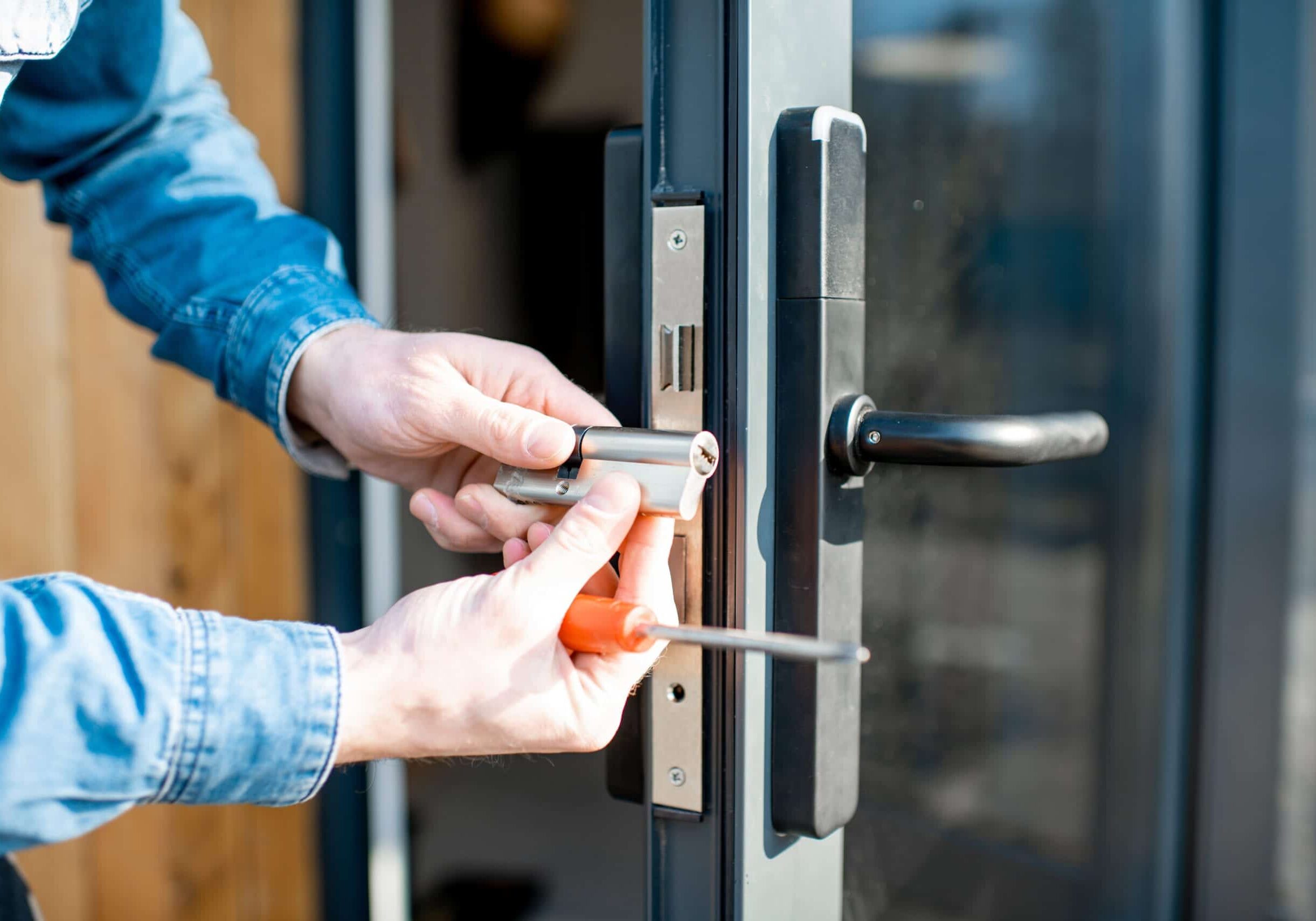 Man changing core of a door lock Man changing core of a door lock of the entrance glass door, close-up view with no face